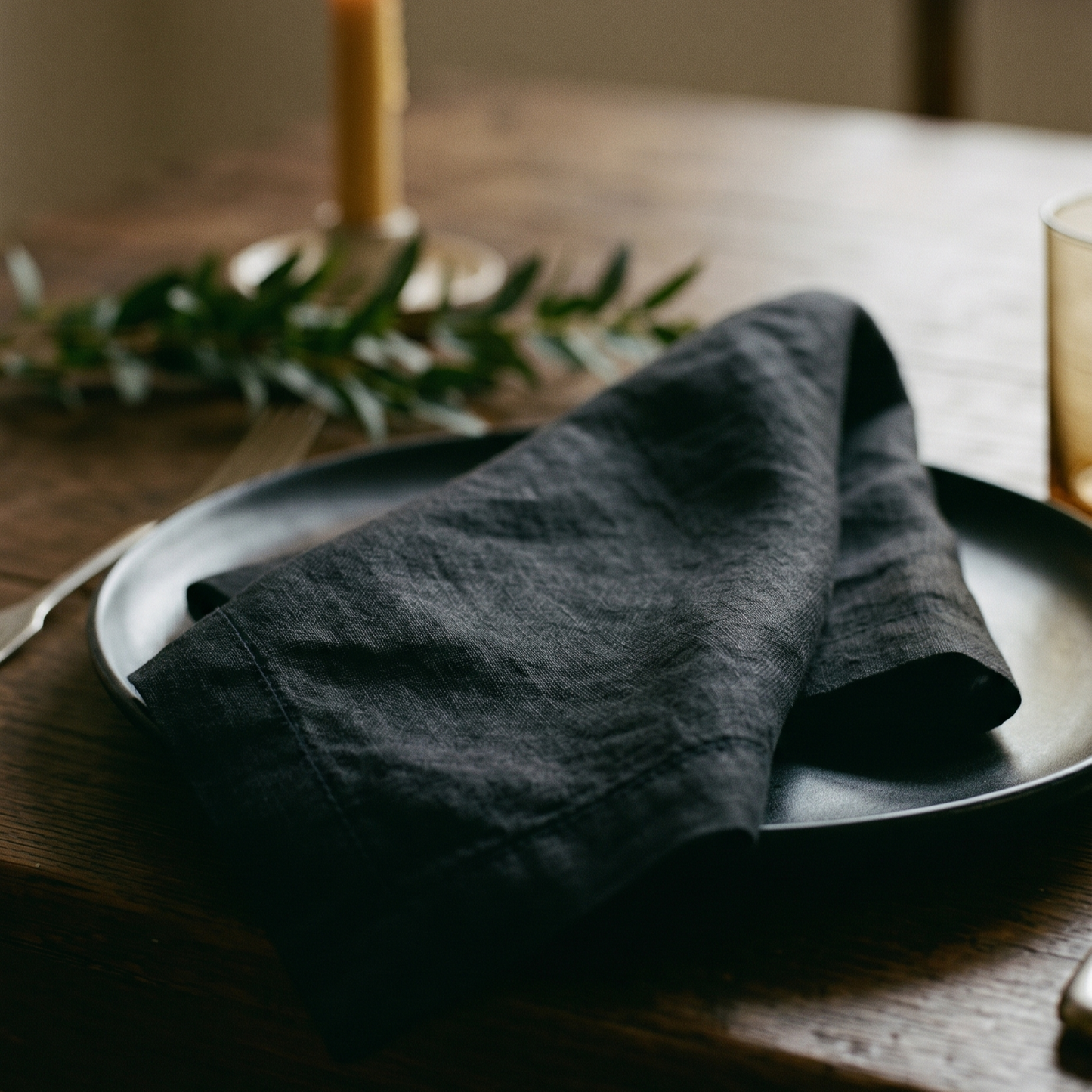 Black plain linen napkin shown at a styled table setting
