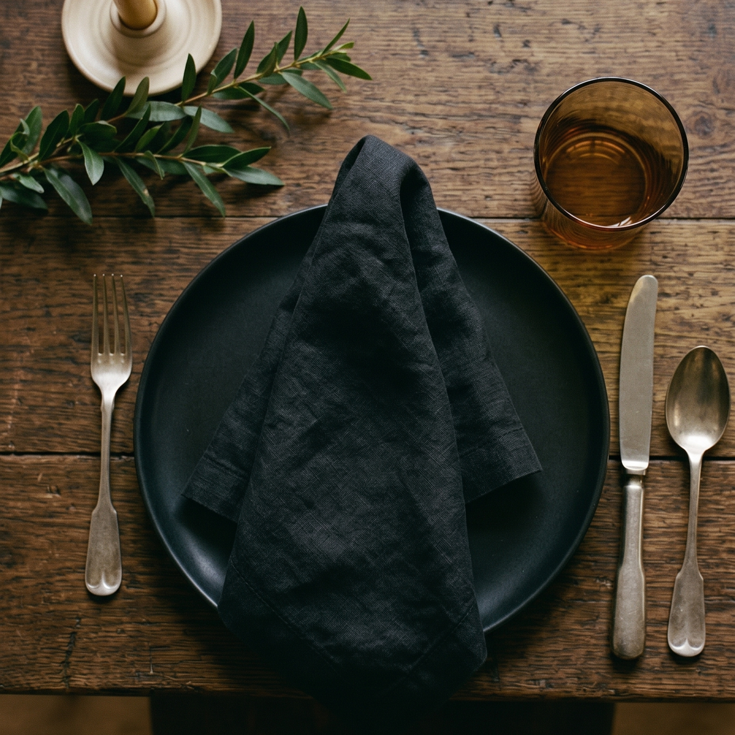 Black plain linen napkin styled with complementary tableware