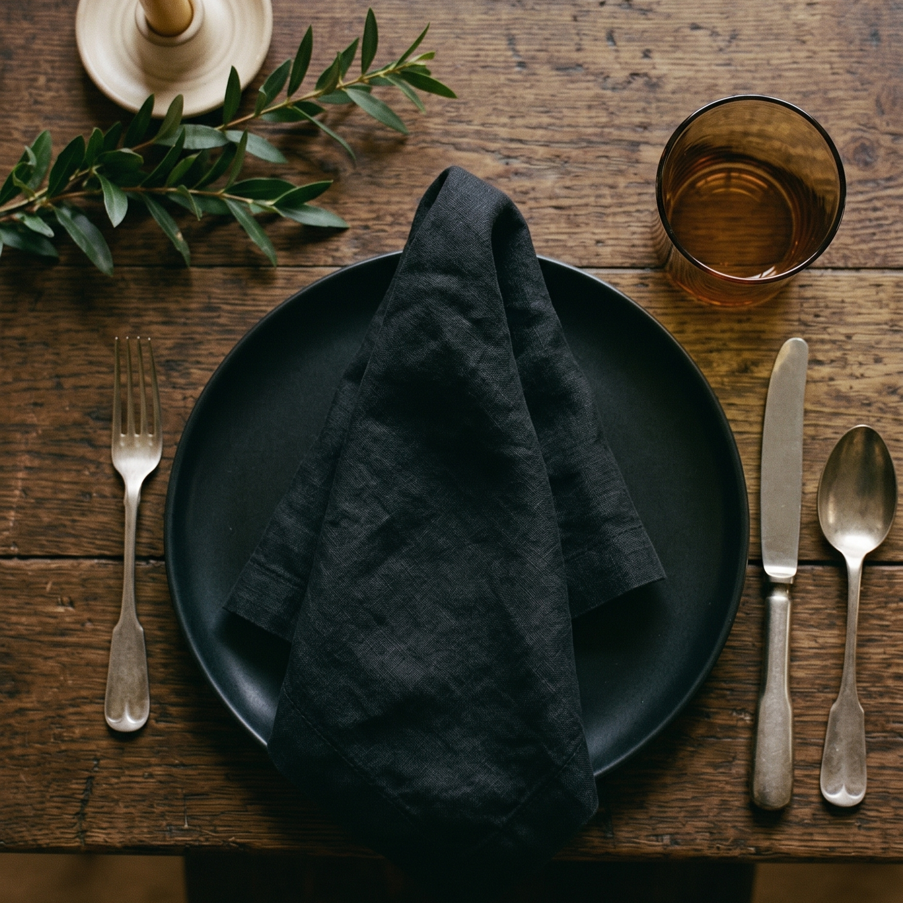 Black plain linen napkin styled with complementary tableware