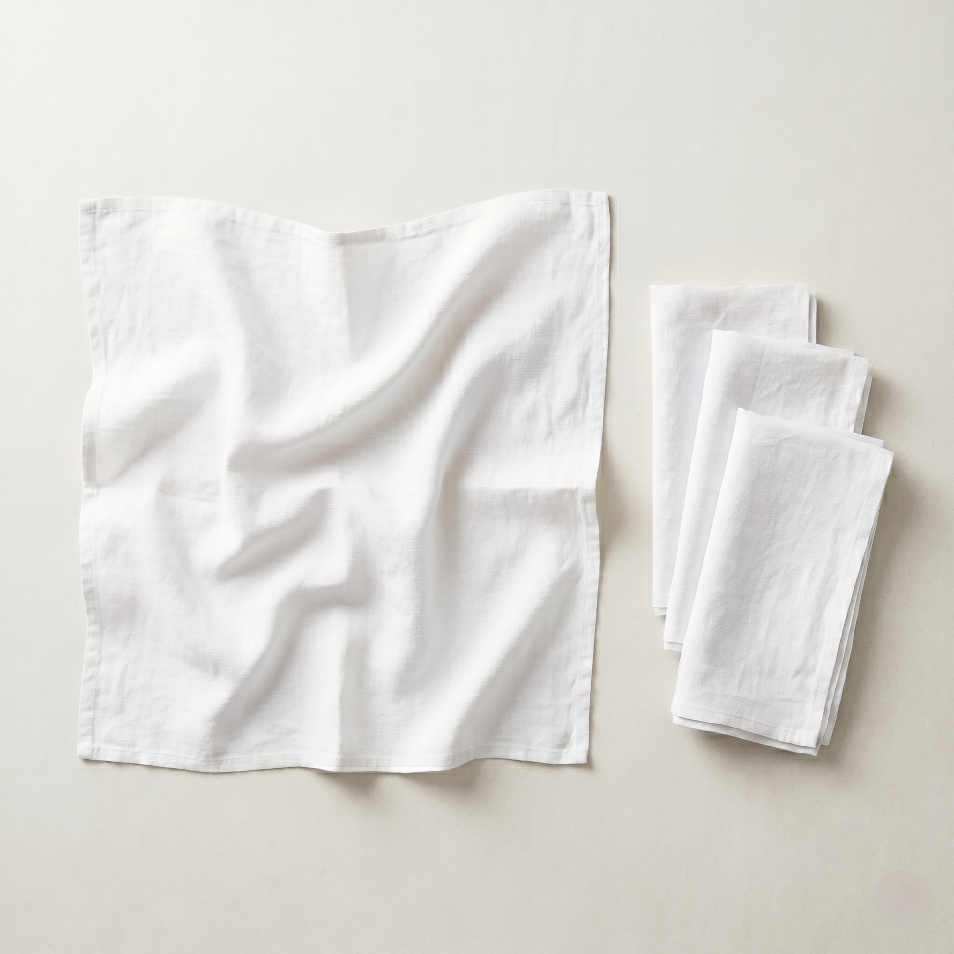Stack of four folded ivory plain linen napkins in soft pure linen