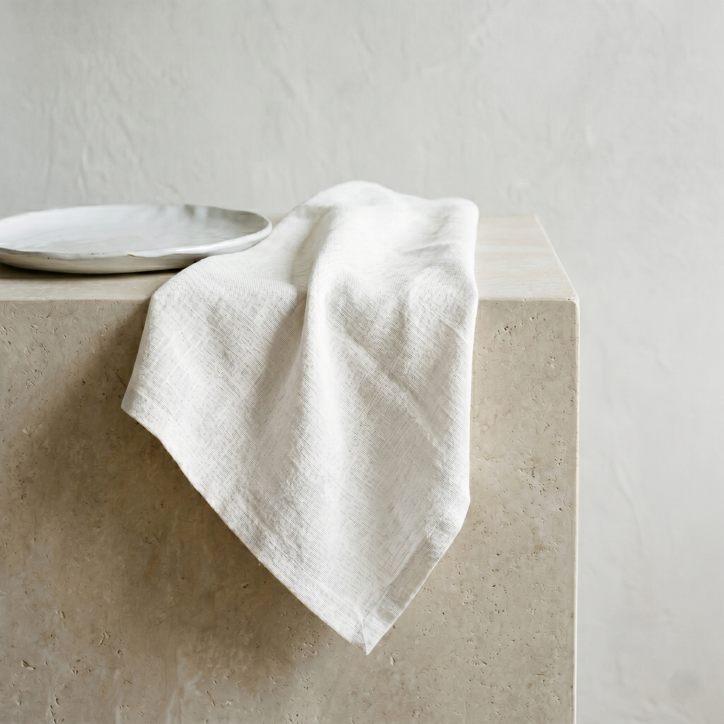 Ivory plain pure linen napkin draped to show its soft, slubby warm-neutral weave
