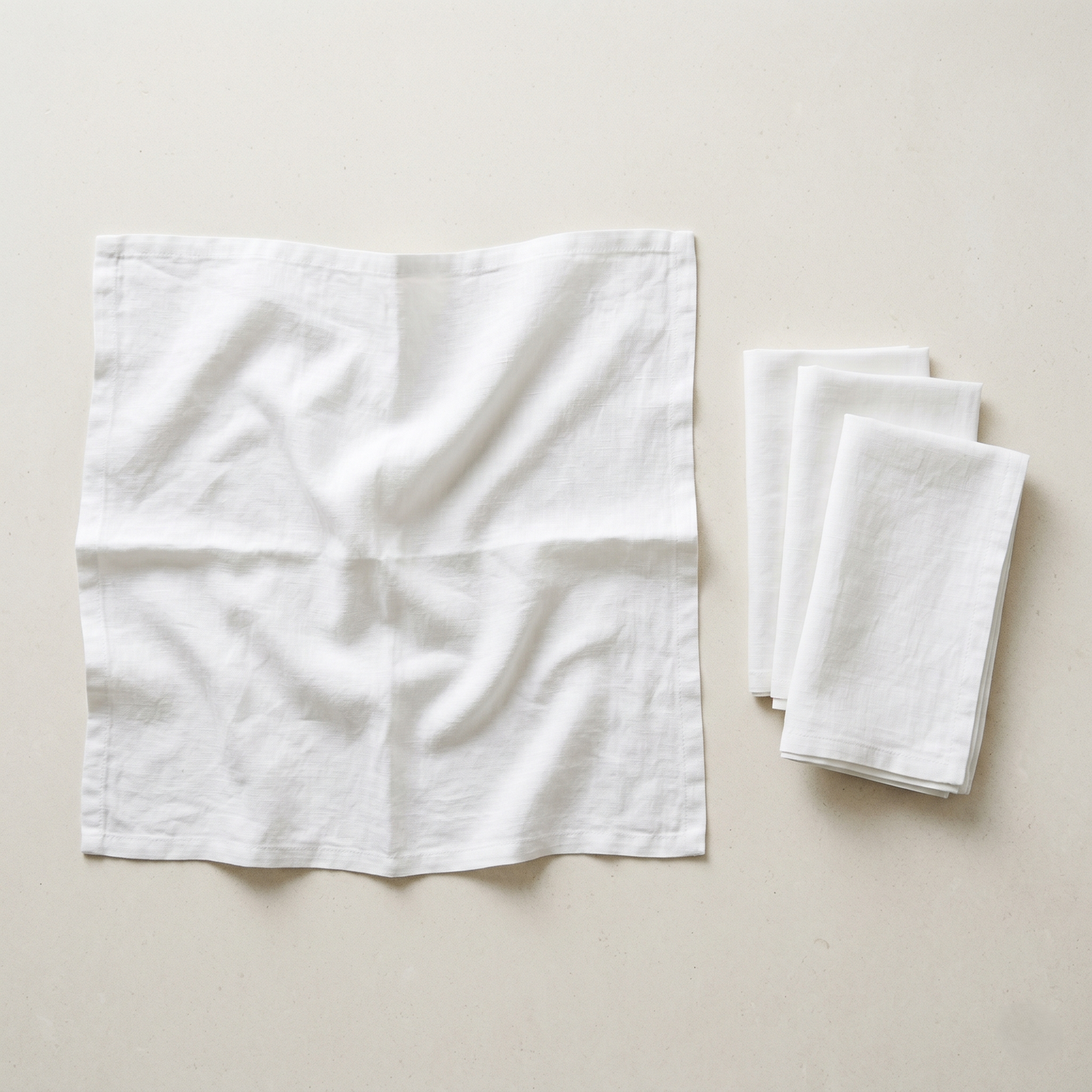 Stack of four folded white plain linen napkins in soft pure linen