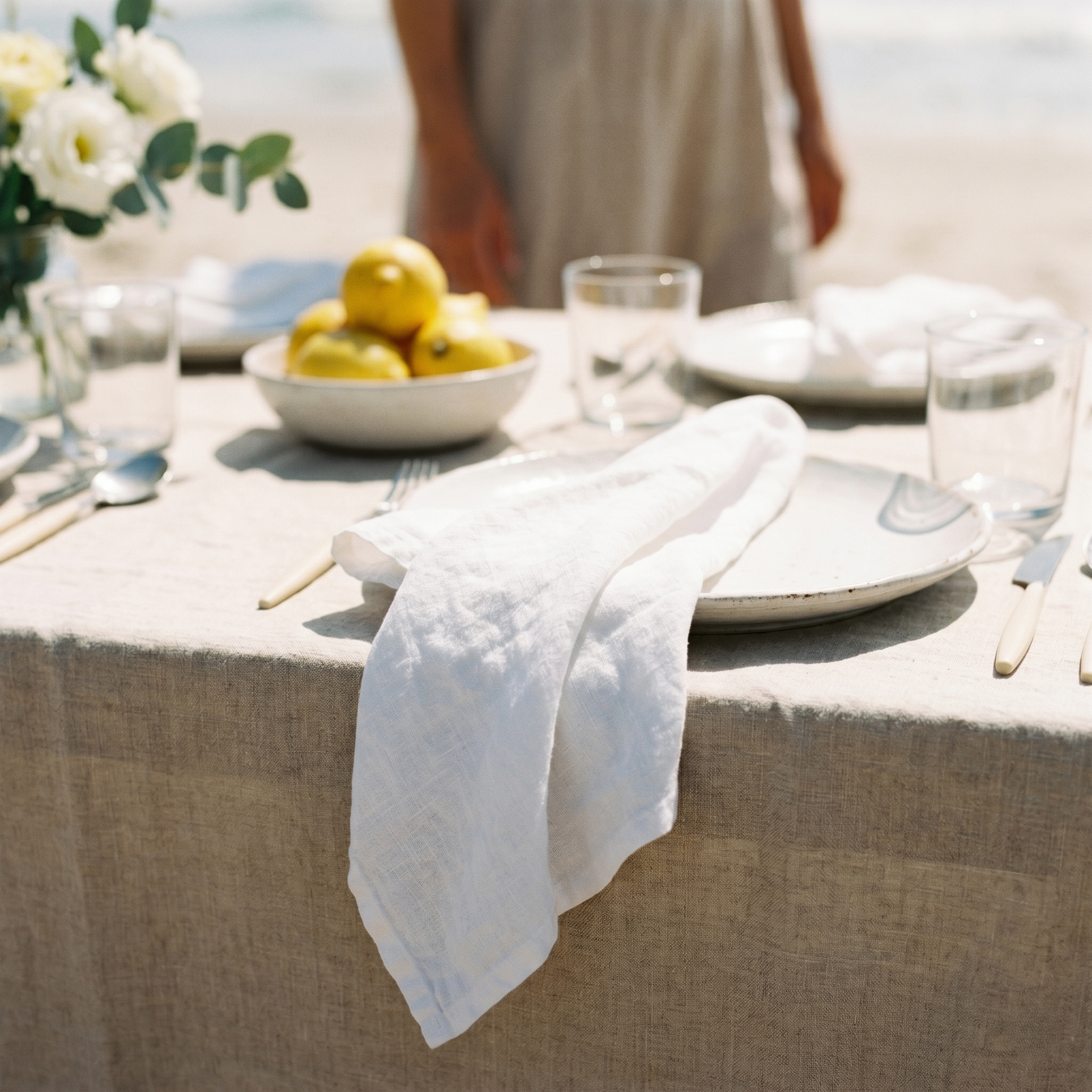 White plain linen napkins styled on a coastal beach table setting